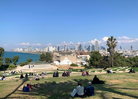 JAFFA, ISRAEL - FEBRUARY 23, 2019: People relax in the amphitheater in Jaffa and watch the panorama of Tel Avivのeditorial素材