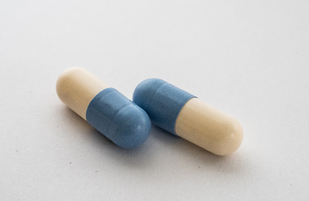 Close-up of two blue-white pill on white backgroundの写真素材