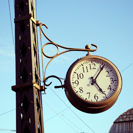 Old street clock in sunny day, Saint-Petersburg, Russiaの写真素材