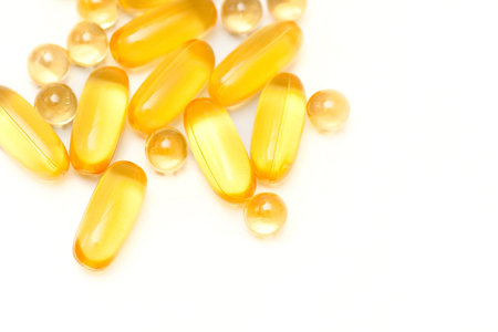 Yellow fish oil capsules on a white background