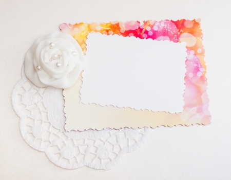 White decorative card on a red and white background with a ribbonの写真素材