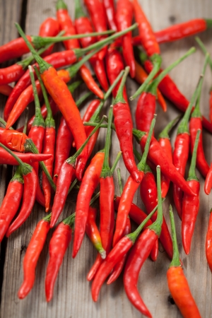 The pods of red chili peppers on a wooden backgroundの写真素材