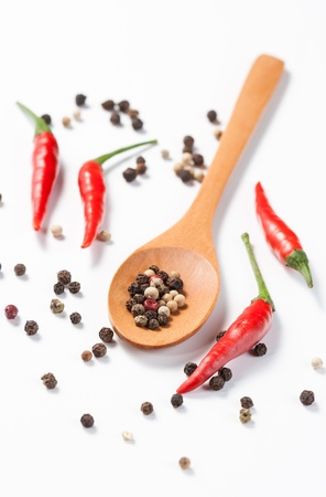 Mixed pepper in wooden spoon isolated on white backgroundの写真素材