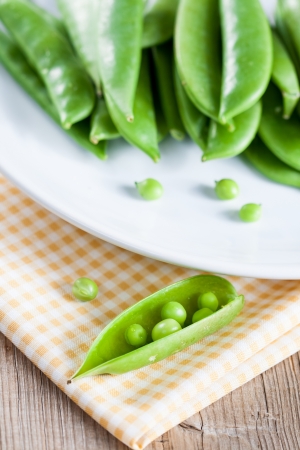 Pods of green peas on a white plateの写真素材