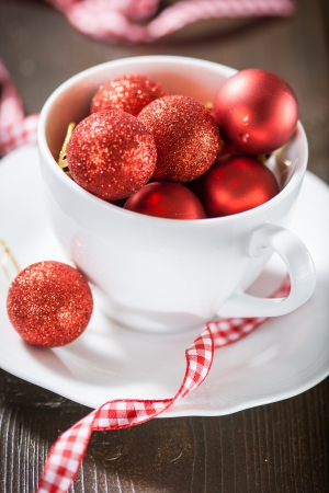 Small red Christmas balls in a white cupの写真素材