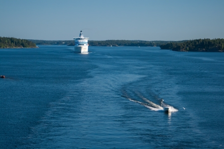 Ferry cruises through the water close to landの写真素材