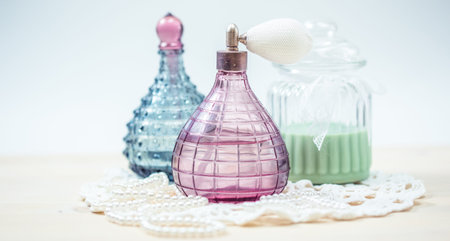 Two glass bottles of female perfume on a white background. Pink toning.の写真素材
