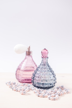 Two glass bottles of female perfume on a white background. Pink toning.の写真素材