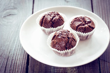 Chocolate muffins with chocolate on white plate.の写真素材