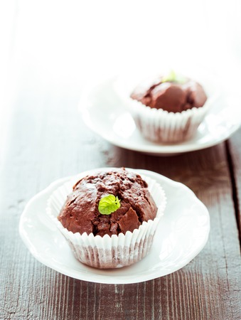 Chocolate muffins with chocolate on white plate.の写真素材