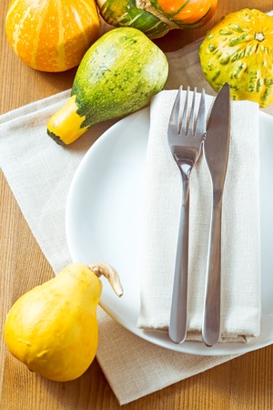 Autumn place setting with Pumpkins. Knife and fork with white linen tied upの写真素材