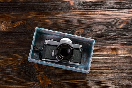 Old film camera, lenses and old exposure meter on a wooden backgroundの写真素材
