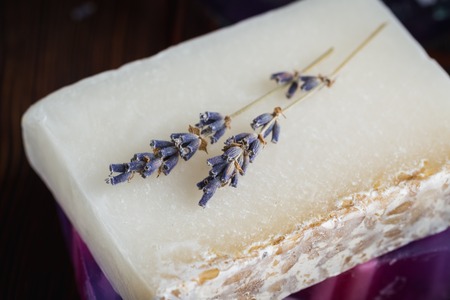 Dried lavender flowers on a white bar of natural soapの写真素材