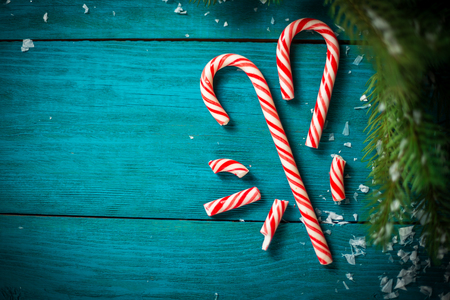 Christmas tree branch with candy cane on wooden table. Top view with copy spaceの写真素材