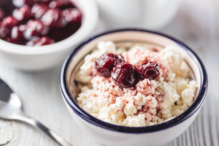 Breakfast from cottage cheese with cherry jam on a white wooden backgroundの写真素材