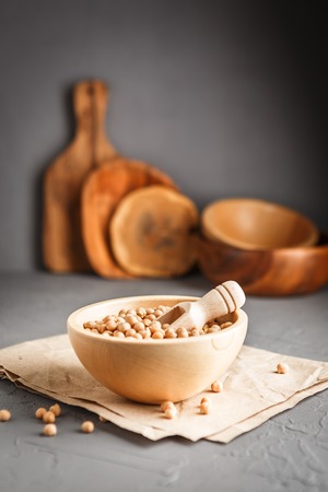 Wooden bowl with dry raw organic chickpeas on gray concrete backgroundの写真素材