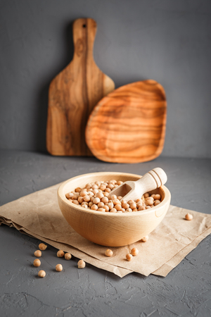 Wooden bowl with dry raw organic chickpeas on gray concrete backgroundの写真素材