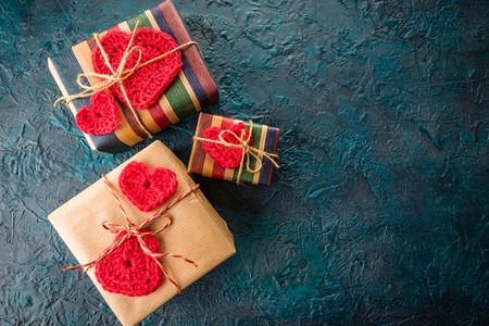 Gift boxes and crochet valentine hearts on dark bacground.の写真素材