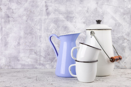 Two white enamel mug, violet jug and white can on light backgroundの写真素材