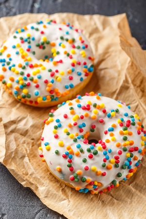 Delicious donuts with white frosting and multicolored crispy ballsの写真素材