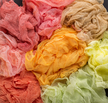 Multicolored background of red, orange, yellow, lemon and crimson colors of gauze fabricの写真素材