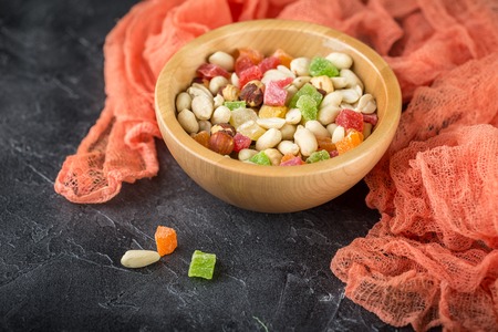The mixture of peanut nuts, hazelnuts and candied fruit in a wooden bowlの写真素材