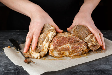 Man man holding three piece of marinated pork shoulderの写真素材