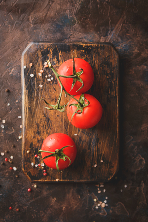 Branch of fresh ripe tomatoes on cutting board. Top viewの写真素材
