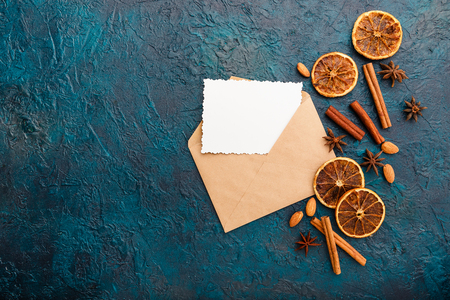 Envelope with greeting card and spices - cinnamon, anise stars, dried oranges and almonds. Flat lay. Top viewの写真素材