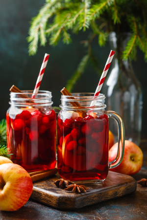 Christmas hot mulled wine with cinnamon cardamom and anise in glass jars on a brown concrete backgroundの写真素材