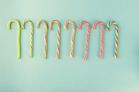 Sweet Candy canes on blue background. Flat lay. Top view.の写真素材