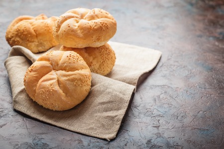 Delicious fresh buns with sesame seeds on a linen napkinの写真素材