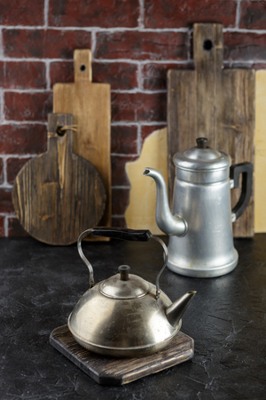 Old metal kettle and coffee pot on a brick wall backgroundの写真素材