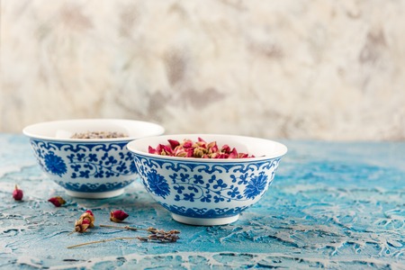 Assortment of dry medicinal herbs roses buds and lavender in bowls.の写真素材