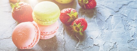 Strawberry Pink and green Macaroons with fresh strawberries on grey background. web banner with copy spaceの写真素材