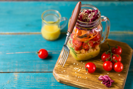 Healthy Homemade Mason Jar Salad with Chickpea, Corn, Carrots, Cucumbers, Bell Peppers, Radish, Arugula and Spinach - Healthy food, Diet or Detox, Vegetarian conceptの写真素材