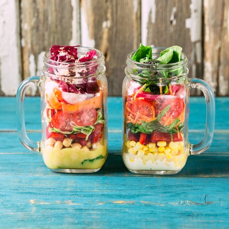 Healthy Homemade Mason Jar Salad with Chickpea, Corn, Carrots, Cucumbers, Bell Peppers, Radish, Arugula and Spinach - Healthy food, Diet or Detox, Vegetarian conceptの写真素材