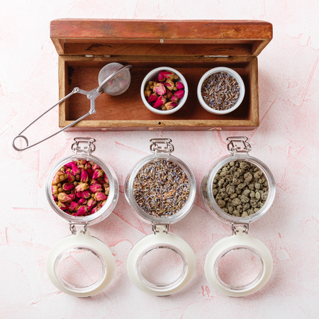 Dried rose flower buds and flowers in glass jars. Herbal tea, cleansing, organic bio products. Top view.の写真素材