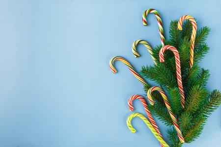 Sweet Candy canes on blue background. Flat lay. Top view.