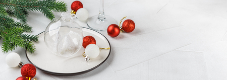 Festive place setting for christmas dinner on white rustic background. Christmas table setting with red and white decorations. Copy space. Long wide bannerの写真素材