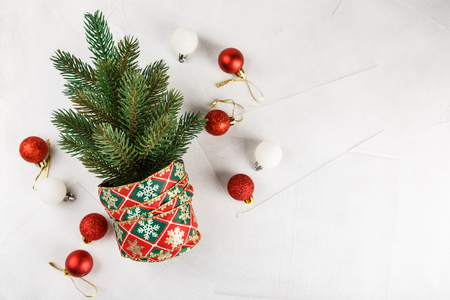 Small decorated Christmas tree with red bells on white. Top view. Space for text.の写真素材