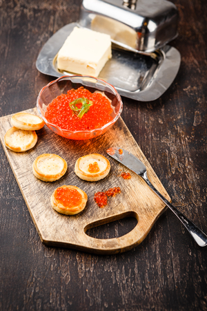 Tartlets with red caviar, champagne and butter on a festive table. Traditional Russian Christmas or New Year's holiday tableの写真素材