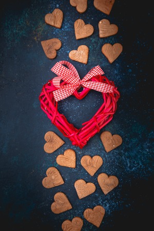 Valentine cookies with heart shape and decorative heart on dark blue backgroundの写真素材