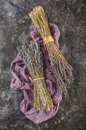 Two bunches of Dried lavender on dark wooden tableの写真素材