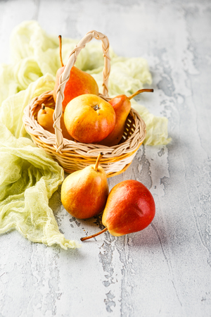 Fresh bio yellow and red pears in basket on the grey backgroundの写真素材
