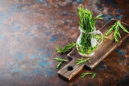 Fresh Rosemary bound on a wooden cutting board. Space for text.の写真素材