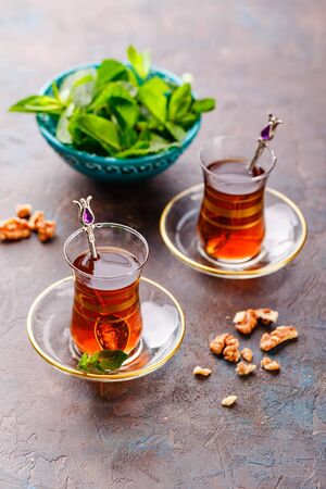 Traditional Turkish arabic dessert and a glass of tea with mint and nutsの写真素材