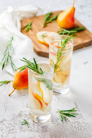 Summer drinks, rosemary pear cocktails with ice in glasses. Refreshing summer homemade Alcoholic or non-alcoholic cocktailsor Detox infused flavored waterの写真素材