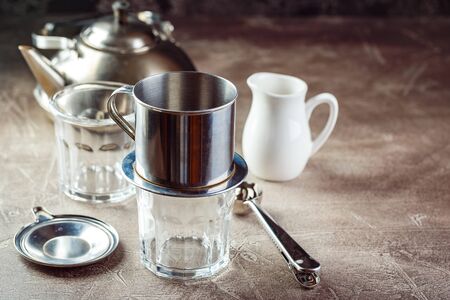 Vietnamese coffee in glass cups and traditional metal coffee maker phin. Traditional method of making of vietnamese coffee. Space for text.の写真素材
