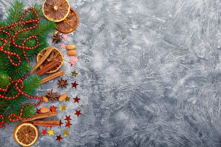 Christmas background with spruce branches, decorations and spices - cinnamon, anise stars, dried oranges and almonds. Top view with copy space.の写真素材